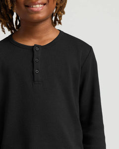 True ClassicBoys' All Black Waffle Long Sleeve Henley worn by smiling boy.