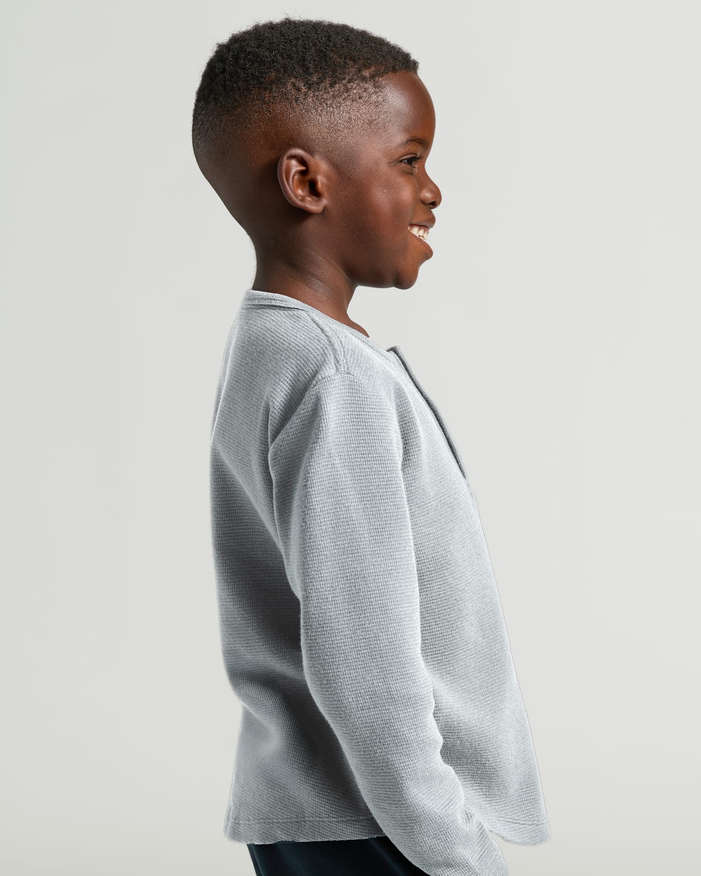 Boy smiling in Boys Heather Gray Long Sleeve Waffle Henley.