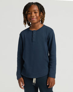 True ClassicBoy wearing Boys Navy Long Sleeve Waffle Henley, smiling gently.