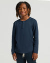Boy wearing Boys Navy Long Sleeve Waffle Henley, smiling gently.