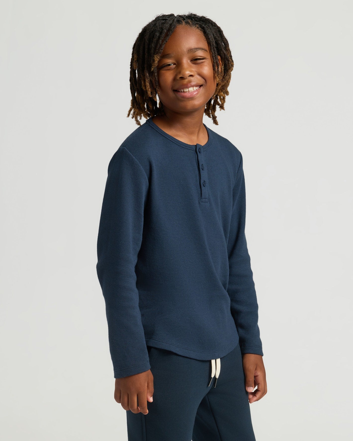 Young person in Boys' Waffle Long Sleeve Henley, navy blue.
