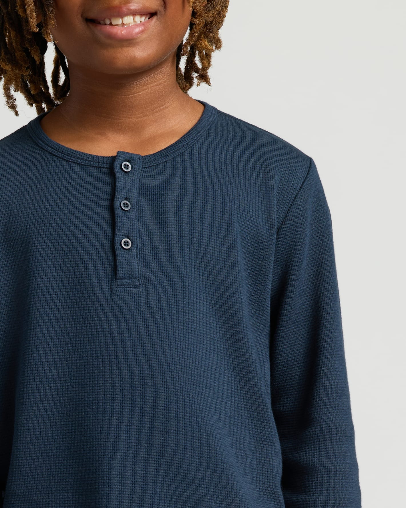 Close-up of person wearing Boys' Waffle Long Sleeve Henley.