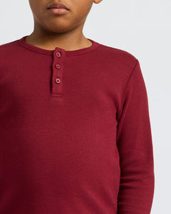 True ClassicChild wearing Boys' Waffle Long Sleeve Henley in deep red, textured knit.