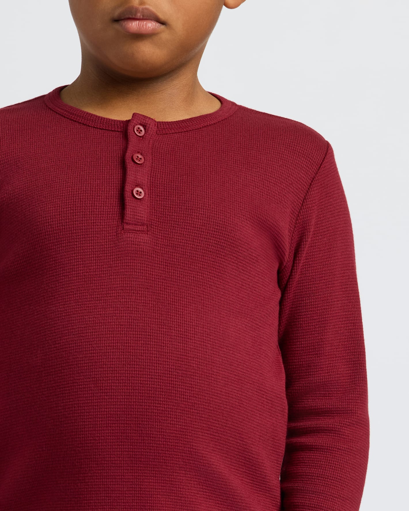Child wearing Boys' Waffle Long Sleeve Henley in deep red, textured knit.
