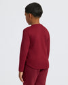 Boy wearing Boys' Waffle Long Sleeve Henley, maroon, side profile.