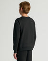 Person wearing a black sweatshirt and pants on a light gray background