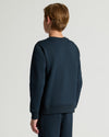 Person wearing a navy blue sweatshirt and pants on a light gray background