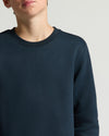 Navy blue sweater worn by a person on a light gray background