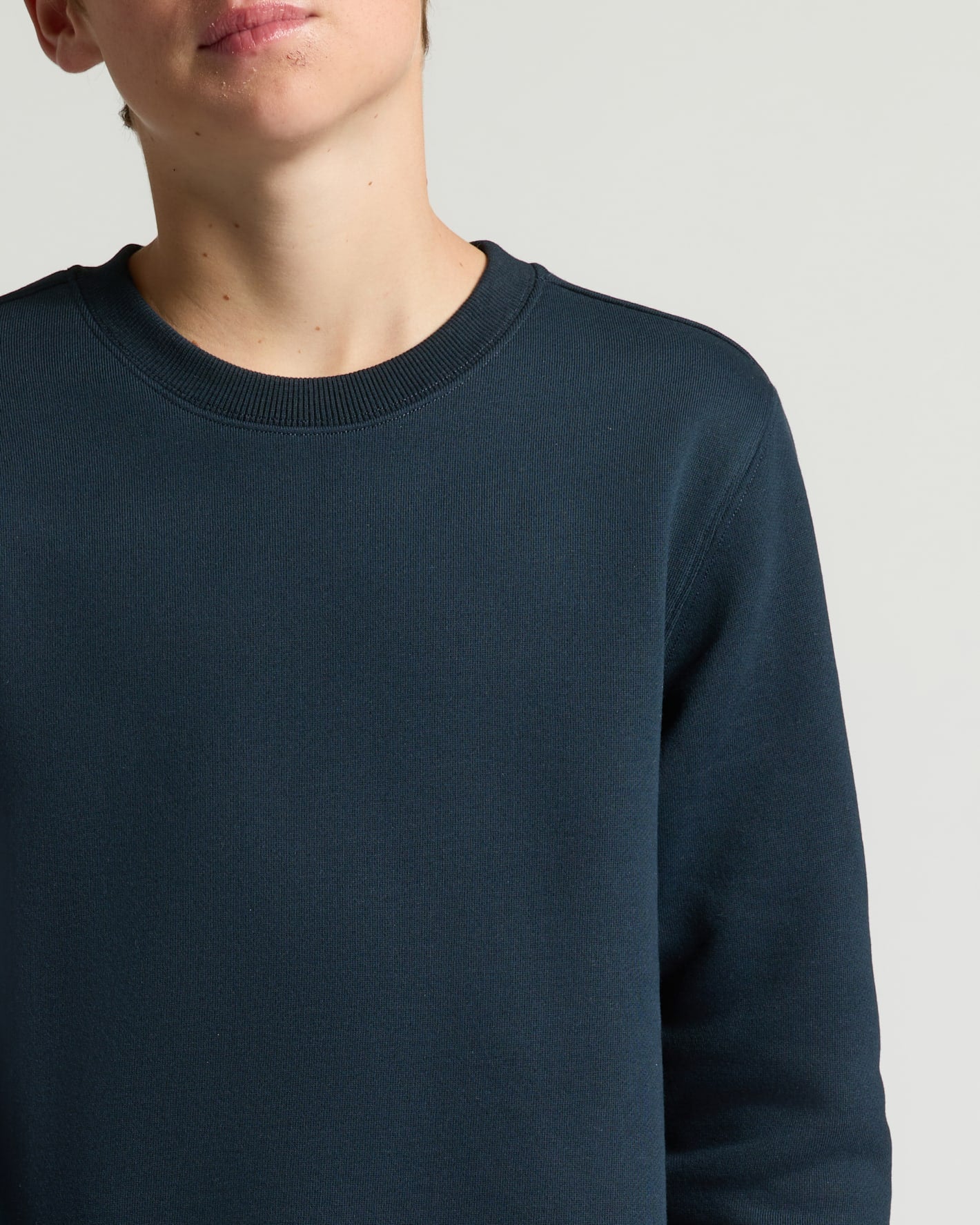 Navy blue sweater worn by a person on a light gray background