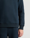 Navy blue sweatshirt worn by a person on a light gray background