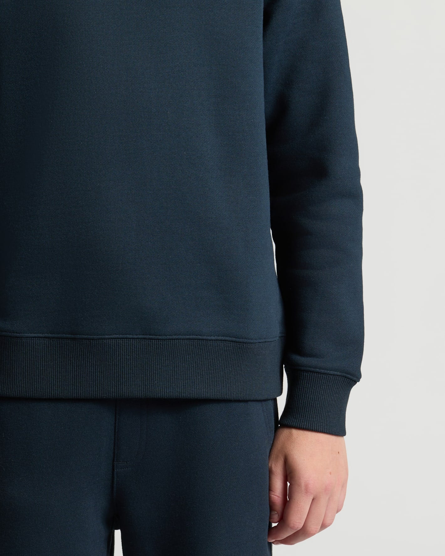 Navy blue sweatshirt worn by a person on a light gray background
