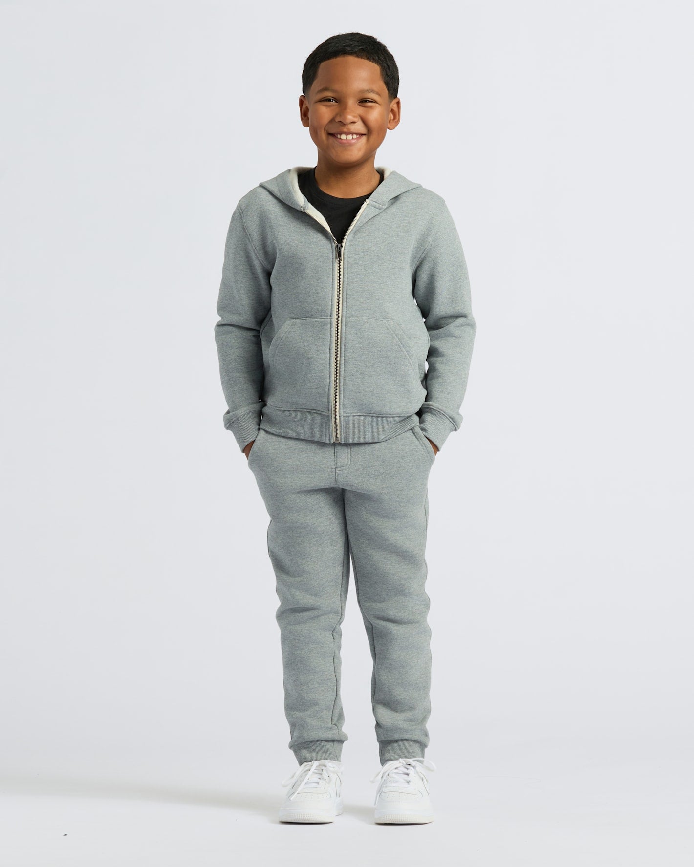 Boy wearing Boys' Medium Heather Gray Fleece Full Zip Hoodie, smiling.