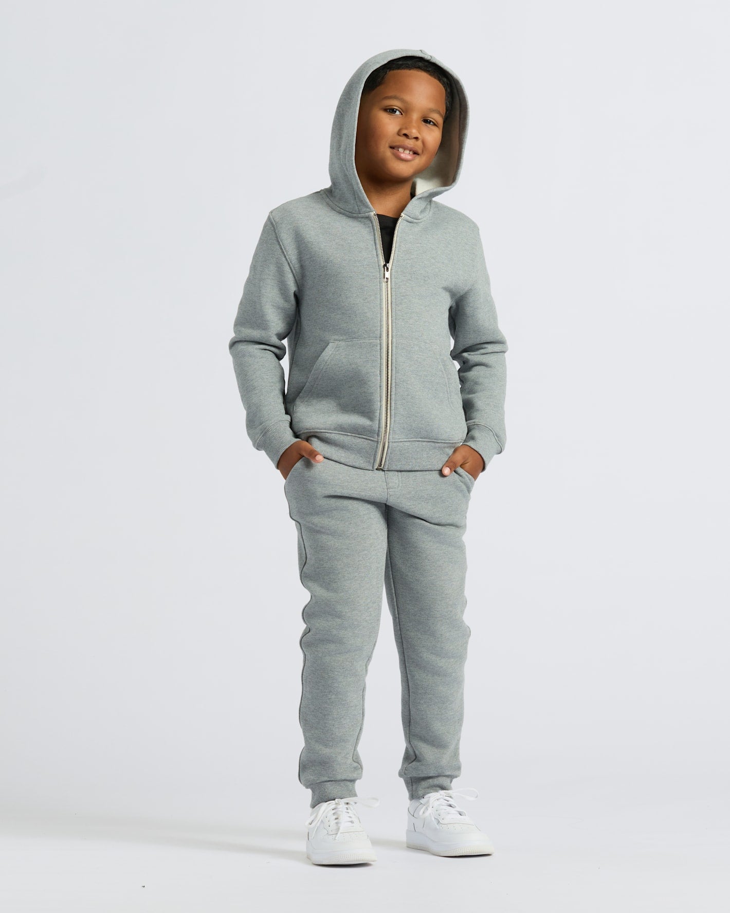 Boy wearing Boys' Medium Heather Gray Fleece Jogger with hoodie and sneakers.