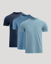 Three short-sleeve crew-neck t-shirts in navy, medium blue, and heather light blue, arranged in a staggered overlapping layout on a light gray background.