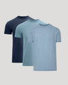 Three short-sleeve crew-neck t-shirts in navy, light blue, and heathered periwinkle blue, arranged in a layered overlapping display on a light gray background.