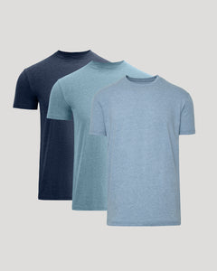 Three short-sleeve crew-neck t-shirts in navy, light blue, and heathered periwinkle blue, arranged in a layered overlapping display on a light gray background.