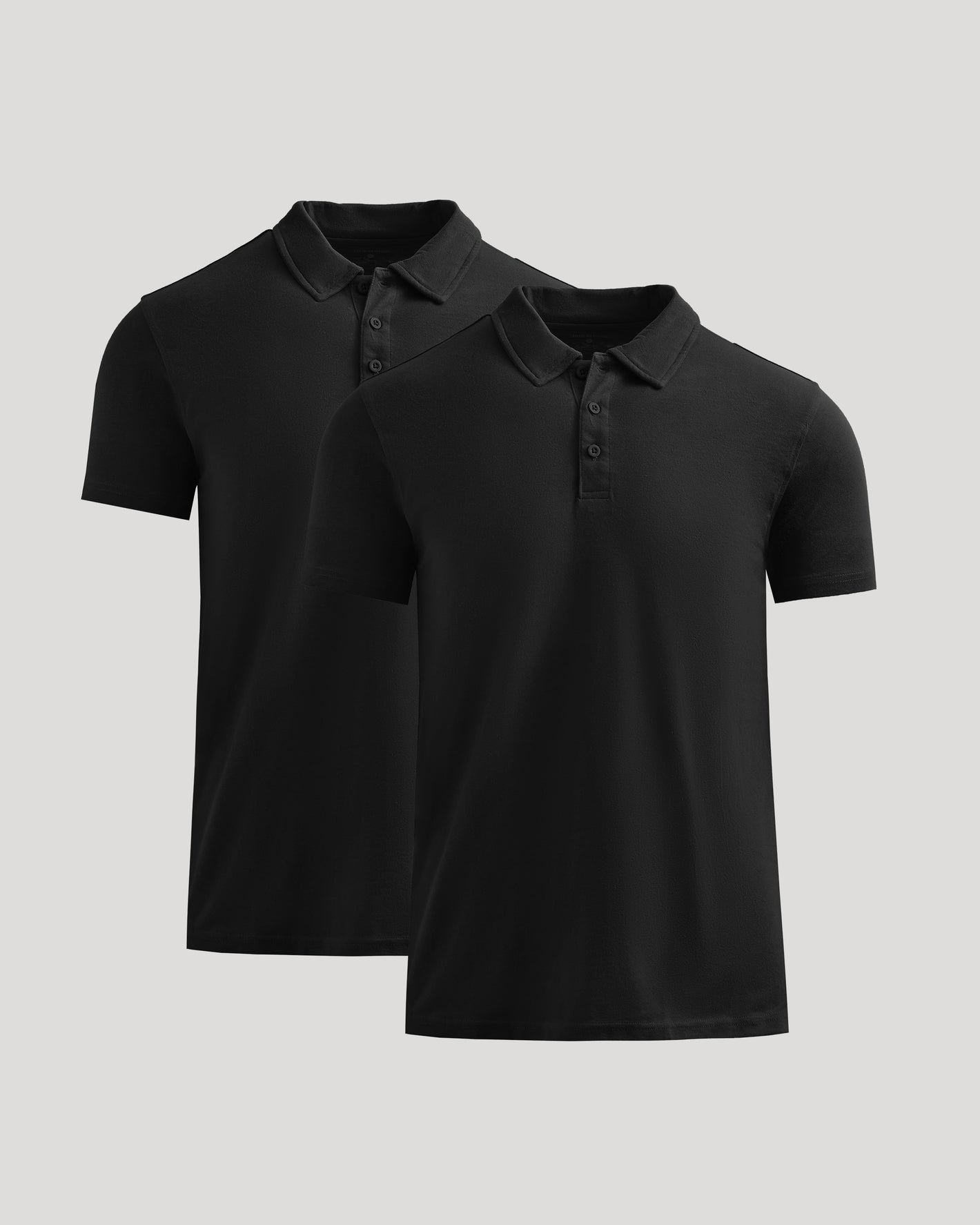 Two black polo shirts on a light gray background