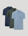 Three polo shirts in navy, green, and blue on a light gray background