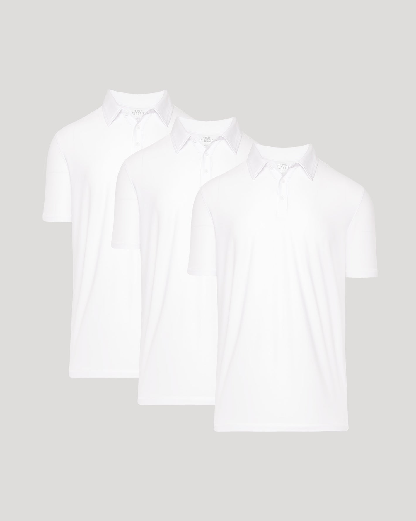 Two white polo shirts on a light gray background