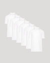 Five white t-shirts stacked on a light gray background