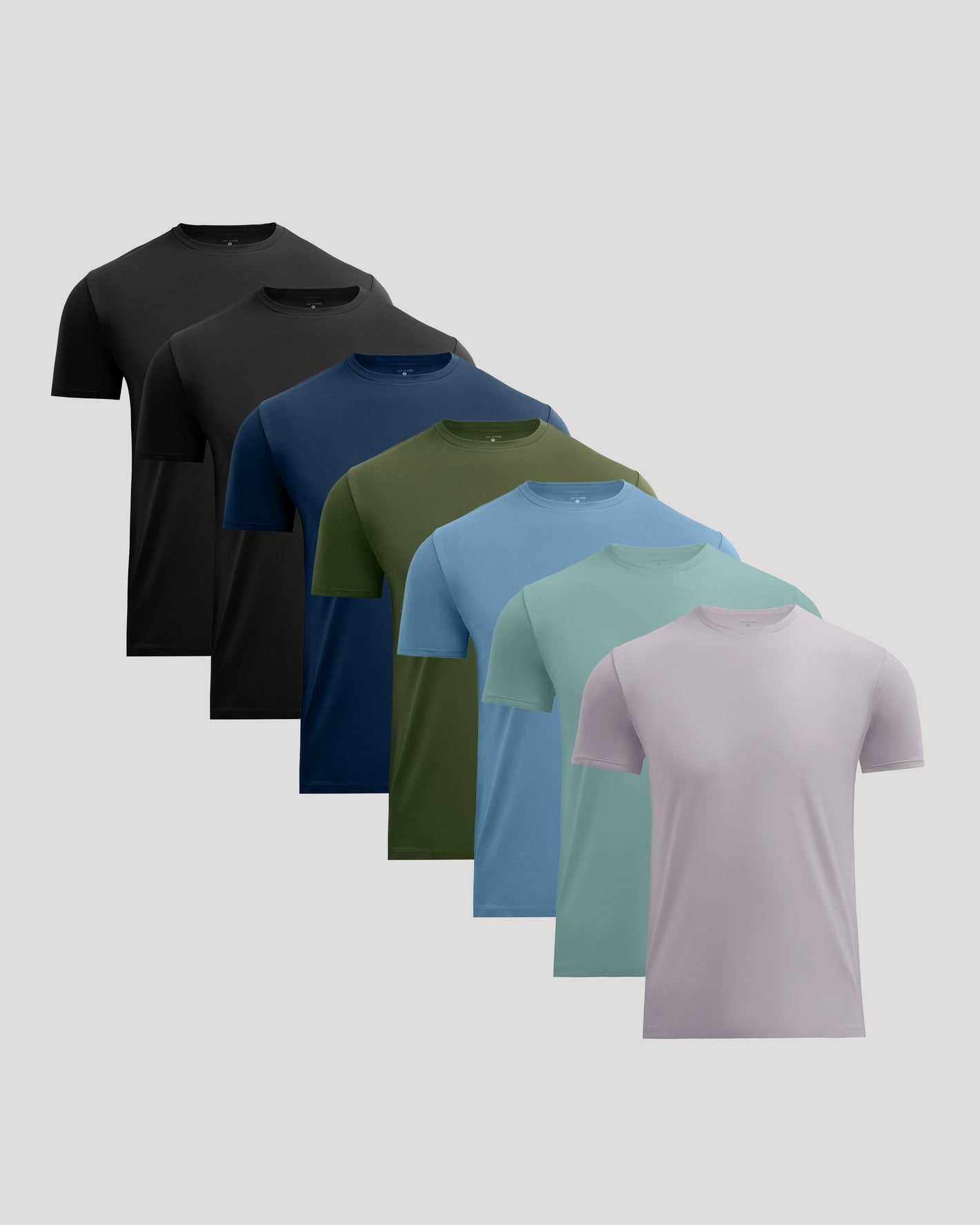 Six short-sleeve crew-neck t-shirts in different colors, arranged in a diagonal stack from back to front on a light gray background. The colors include black, charcoal, navy, olive green, sky blue, mint green, and light lavender.