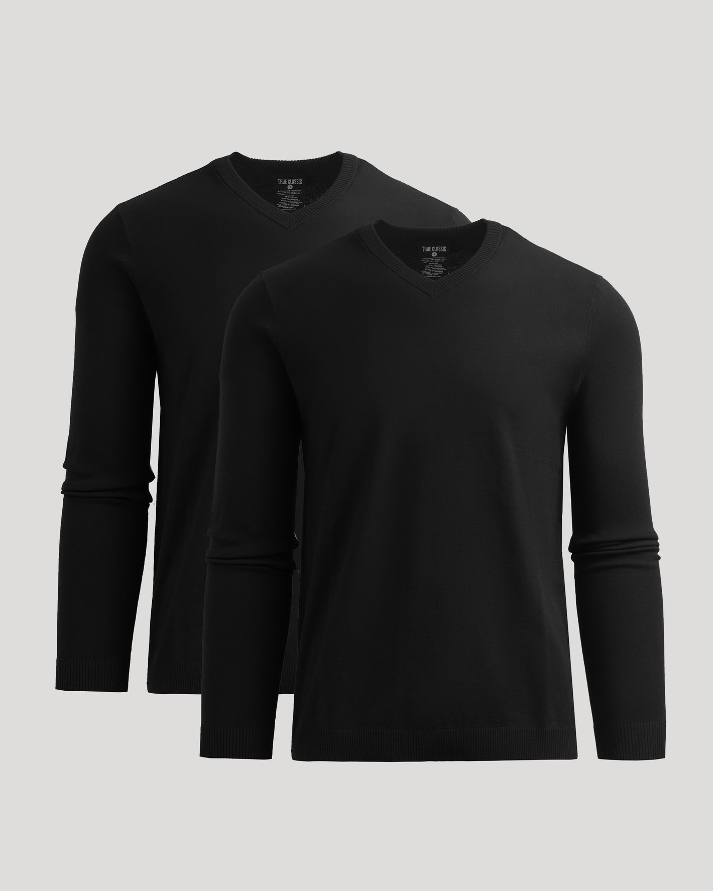 Two black long-sleeve shirts on a light gray background