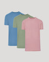 Three t-shirts in blue, green, and pink on a light gray background