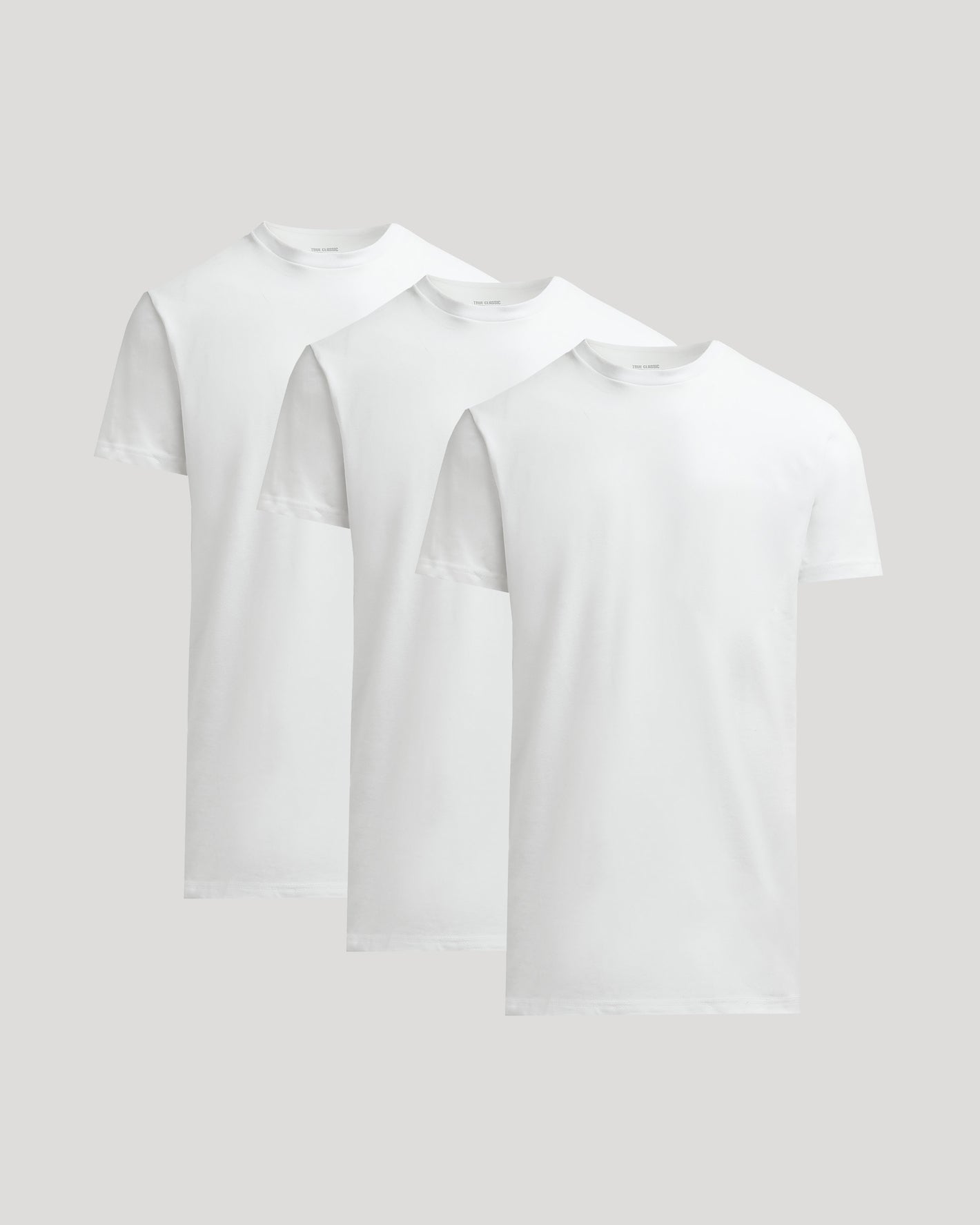Two white t-shirts stacked on a light gray background