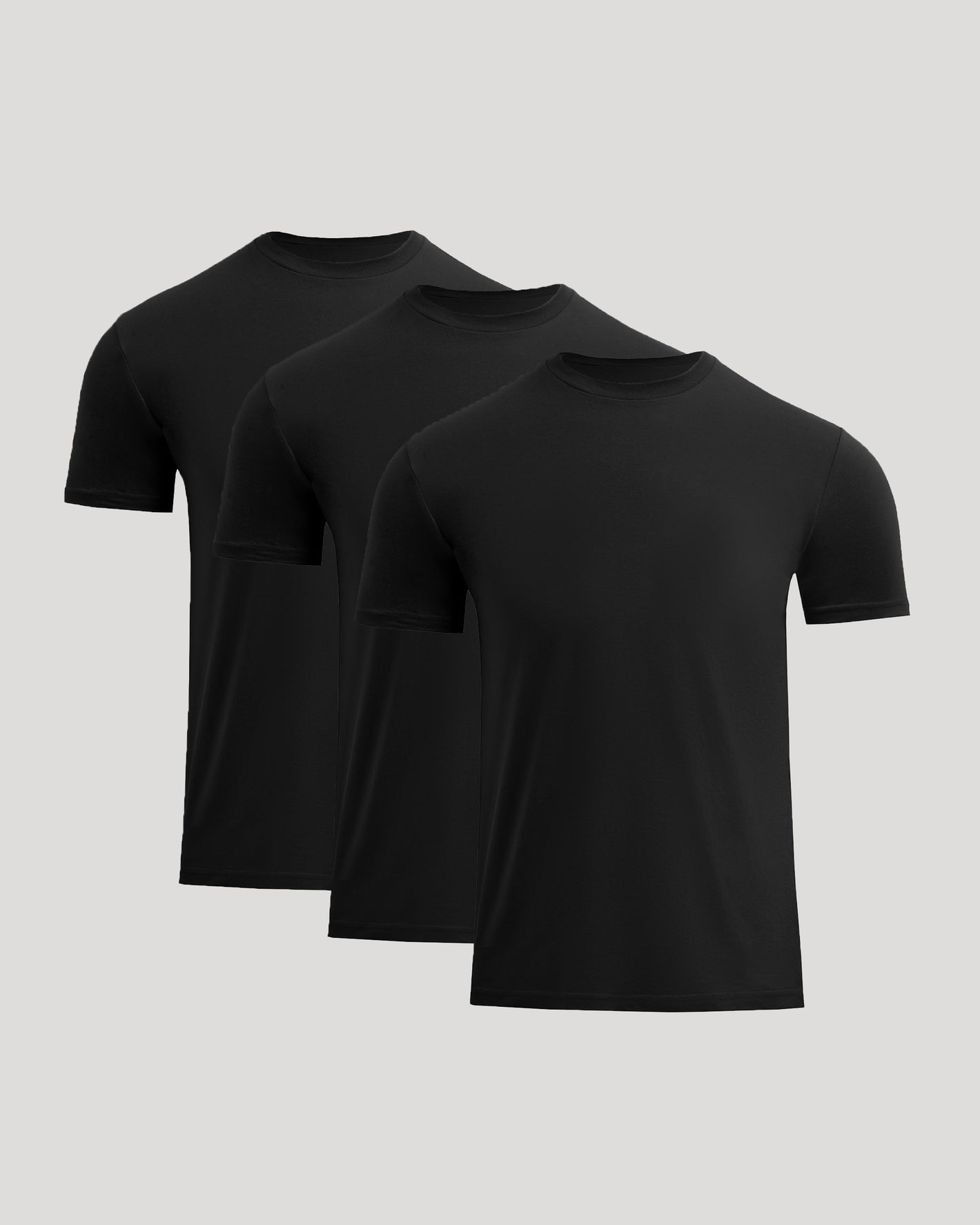 Three black t-shirts stacked on a light gray background