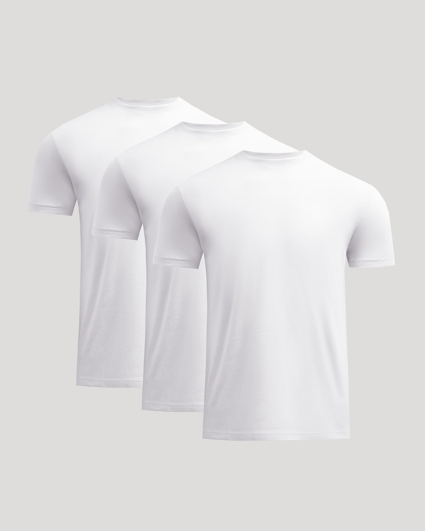 Three white t-shirts stacked on a light gray background