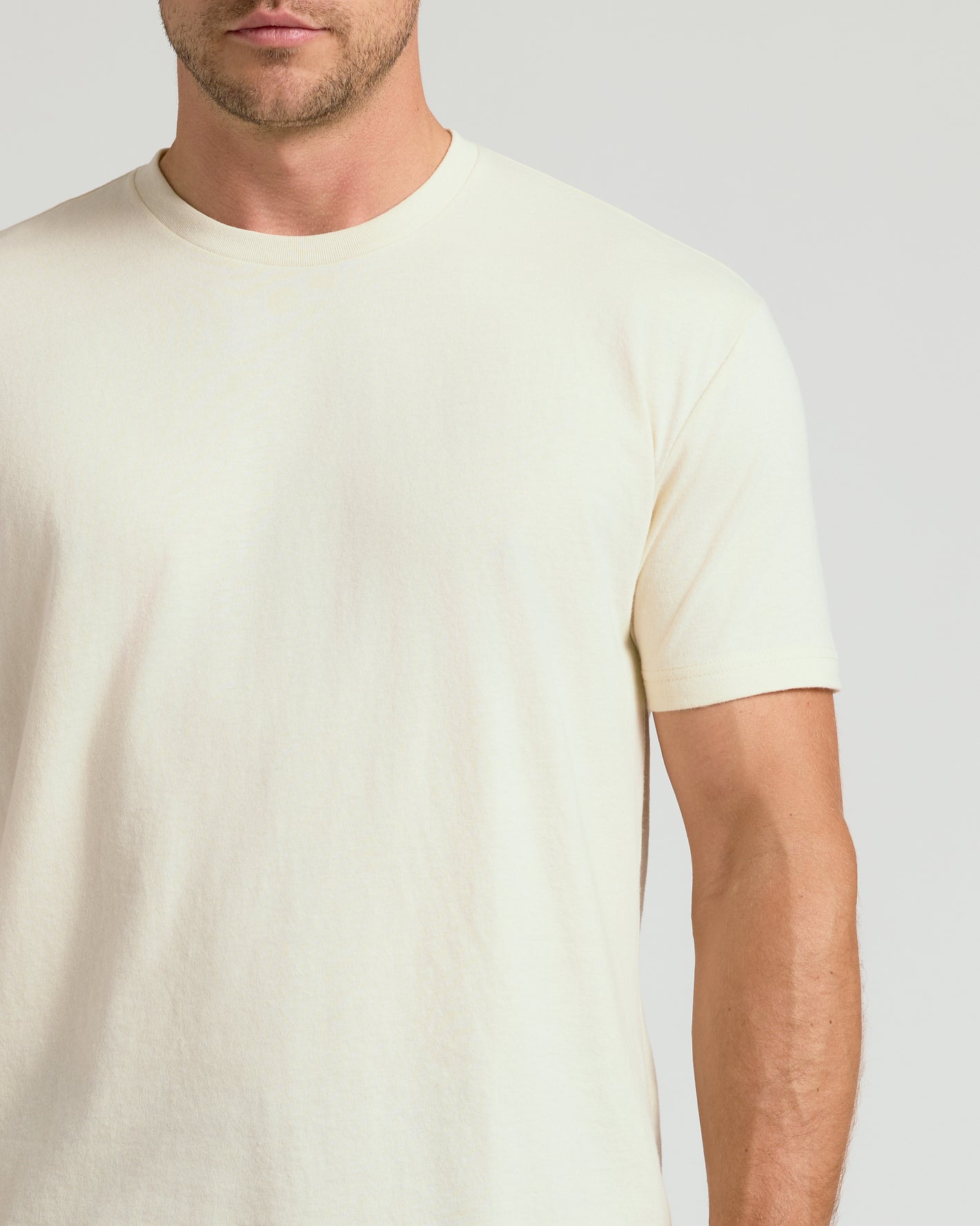Man wearing Alabaster Classic Crew Neck T-shirt, showcasing its fitted design.