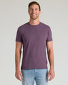 Man wearing Dark Heather Plum Classic Crew Neck, smiling in light blue jeans.