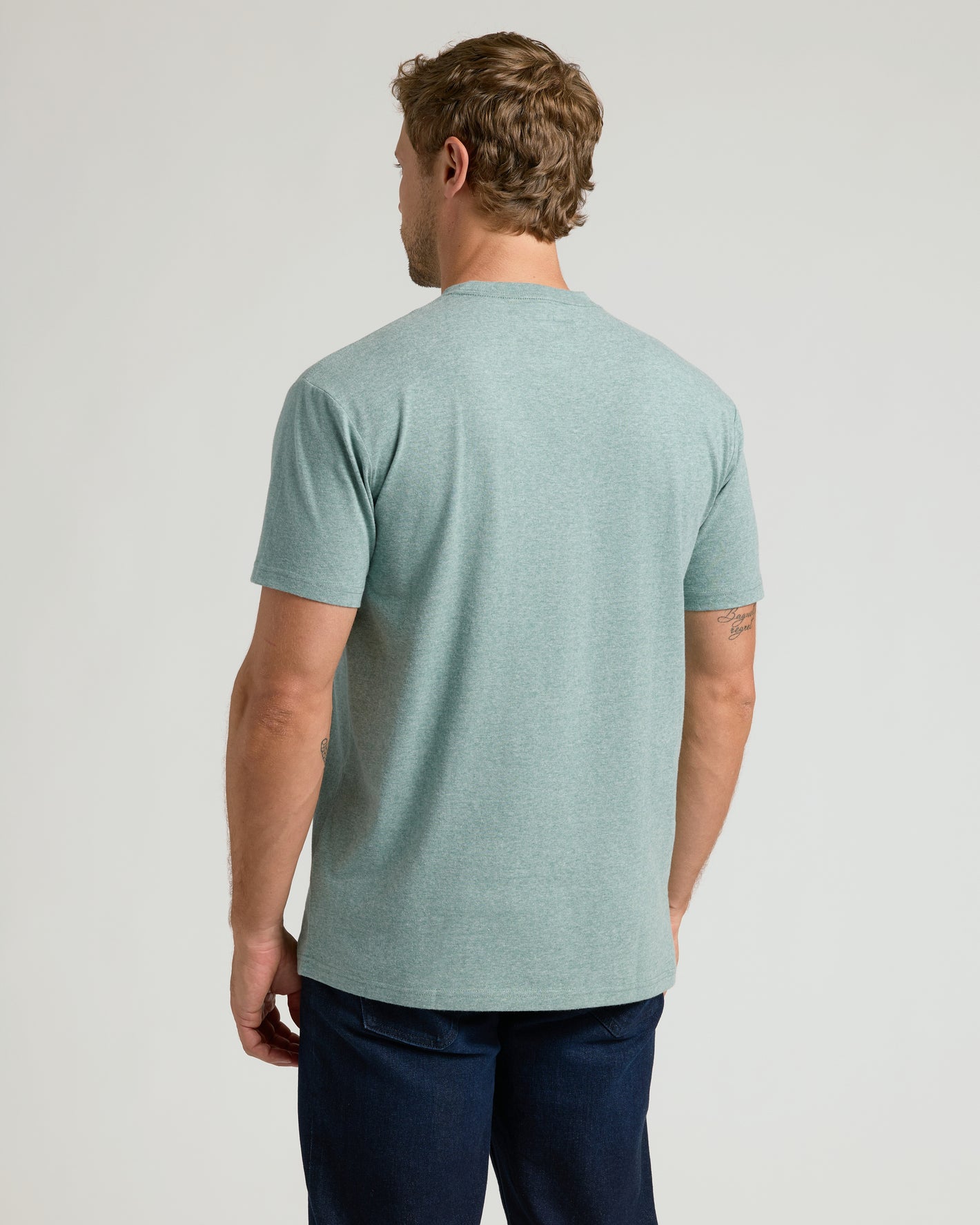 Man in Heather Balsam Classic Crew Neck t-shirt and dark jeans.