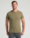 Man wearing an military green t-shirt against a light gray background