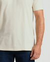 Person wearing a plain white t-shirt and dark pants on a light background