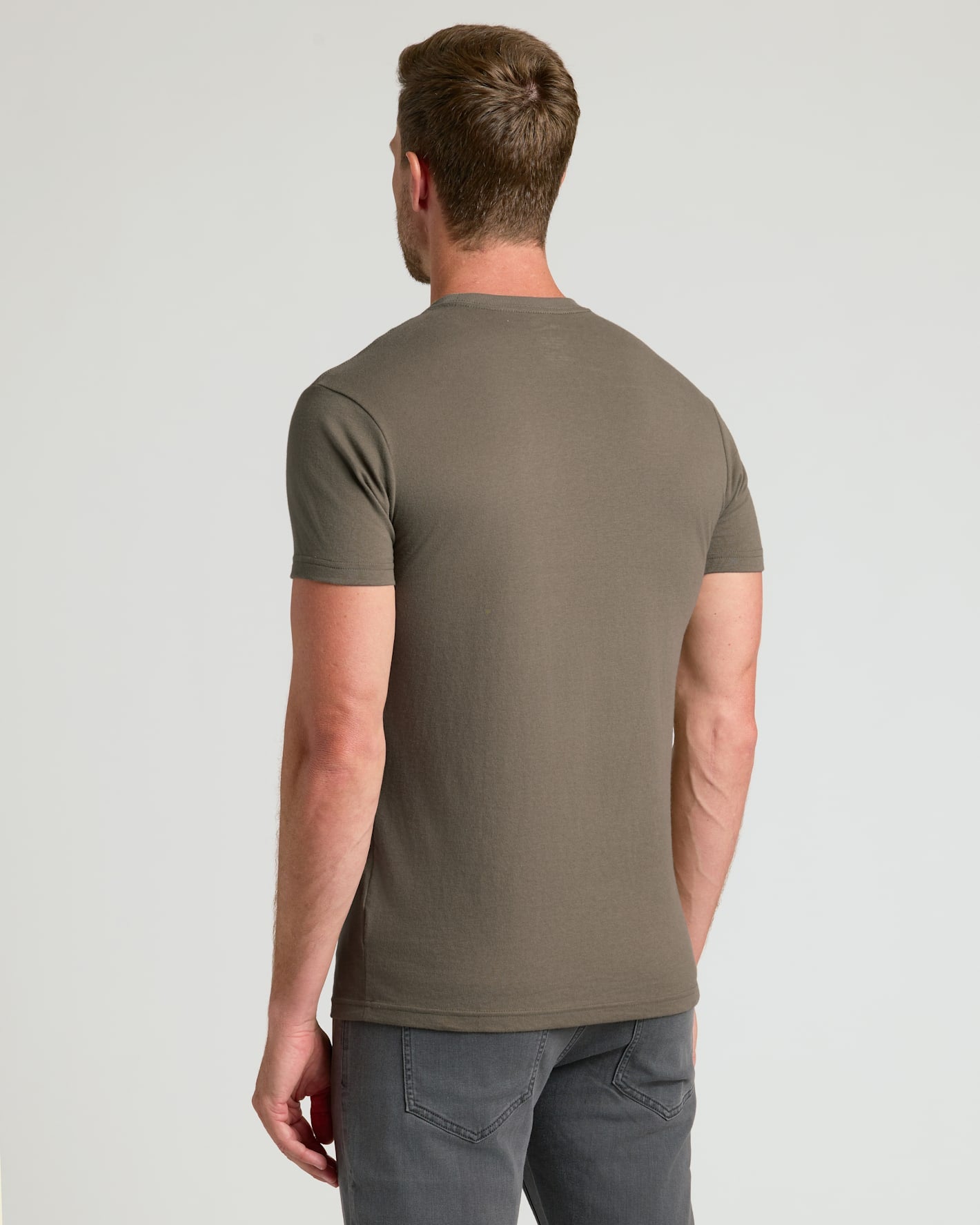 Man wearing Sagewood Classic Crew Neck, back view, with gray jeans.