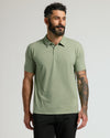 Man wearing Dark Heather Bay Green Classic Polo with tattoos visible.