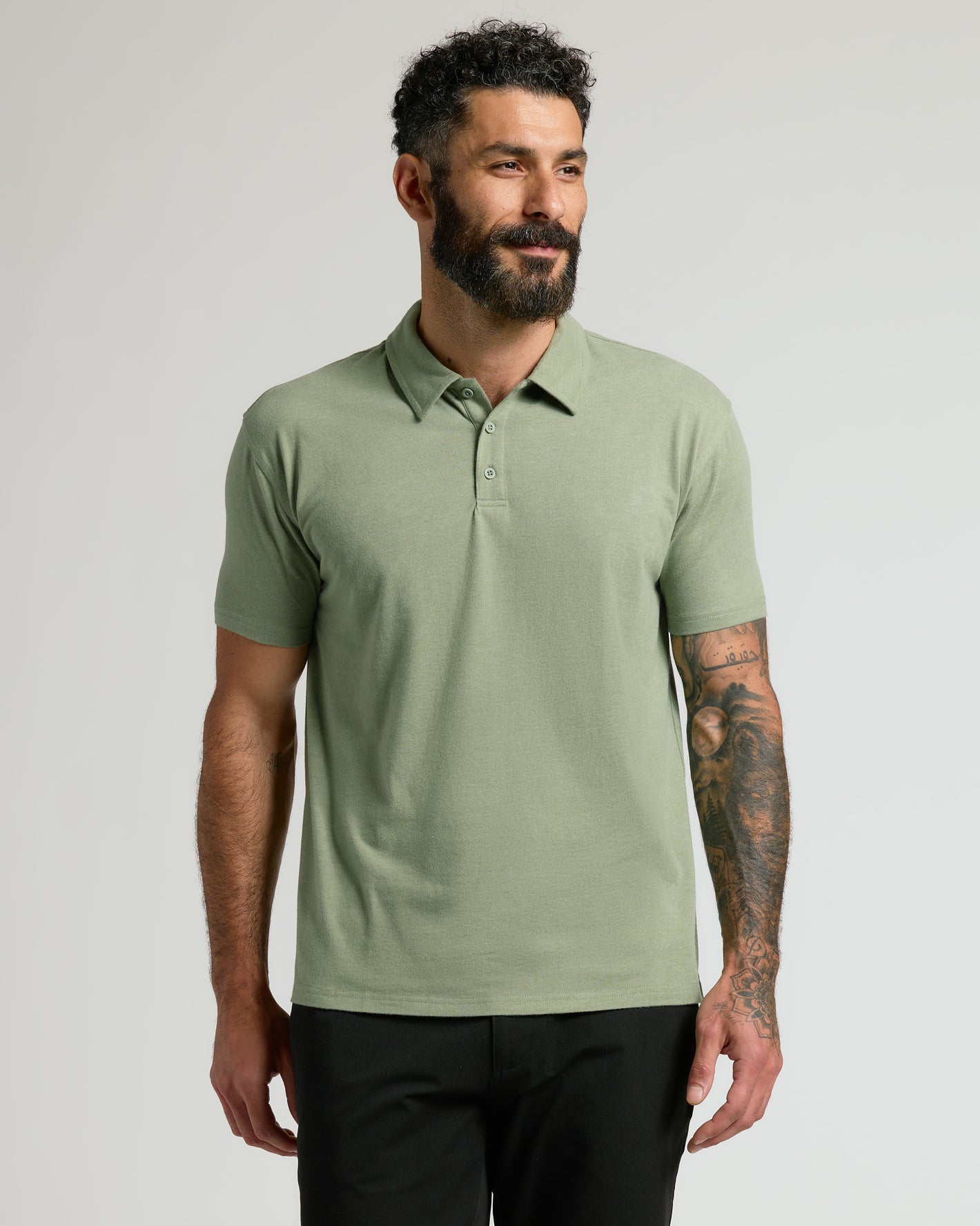 Man wearing Dark Heather Bay Green Classic Polo with tattoos visible.