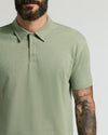 Man wearing Dark Heather Bay Green Classic Polo with tattooed arm.