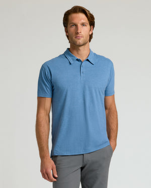 Man wearing Dark Heather Blue Lake Classic Polo and gray trousers.