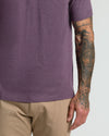 Dark Heather Plum Classic Polo with tattoos visible on forearm and hand.