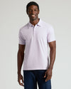 Man in Heather Orchid Classic Polo and dark jeans smiling.
