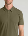 A man wearing a short-sleeve polo shirt in olive green, shown from the chin down against a light gray studio background.