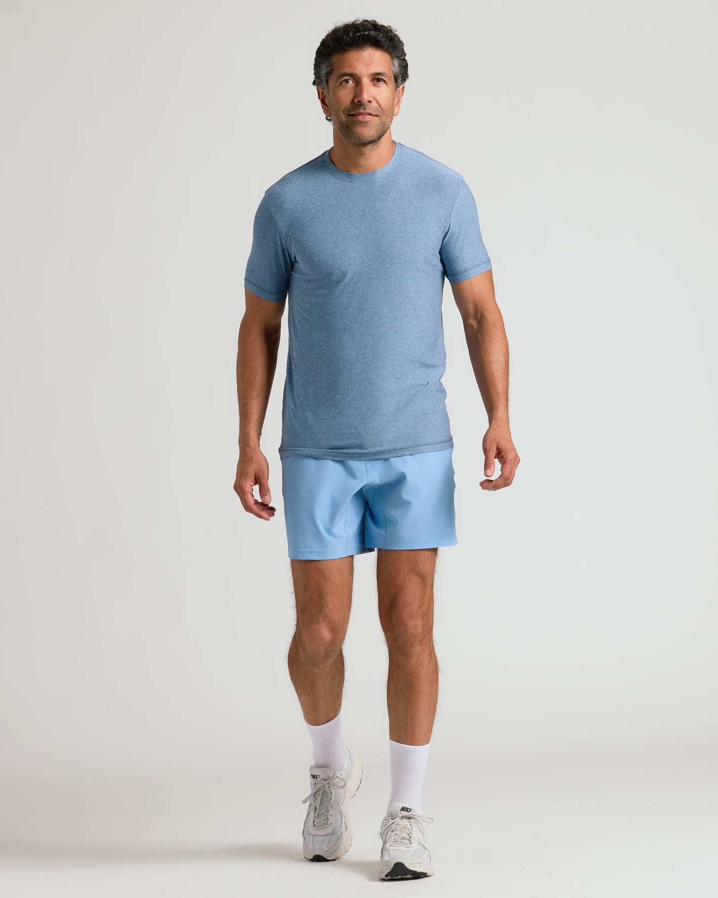 Man wearing Heather Azul Active Crew Neck Tee with matching athletic shorts.