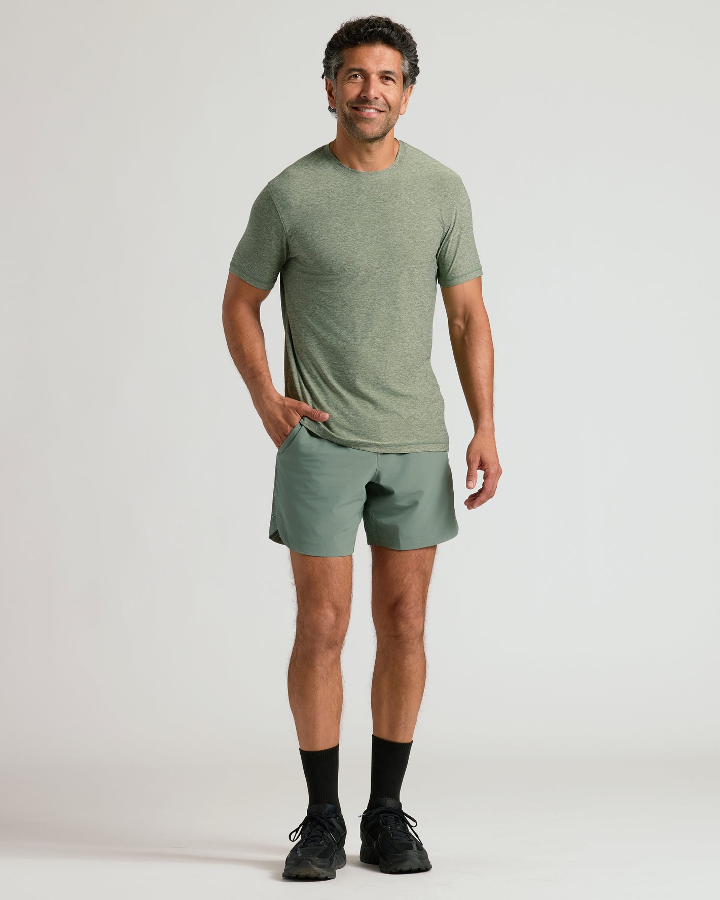 Man wearing Heather Juniper Active Crew Neck Tee and matching athletic shorts.