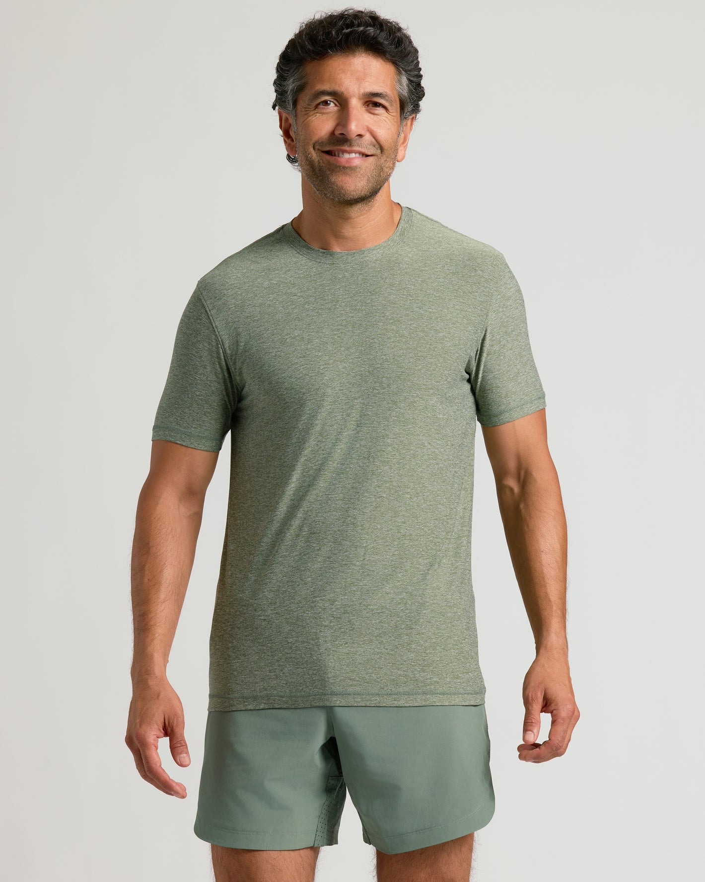 Male model wearing Heather Juniper Active Crew Neck Tee and shorts.