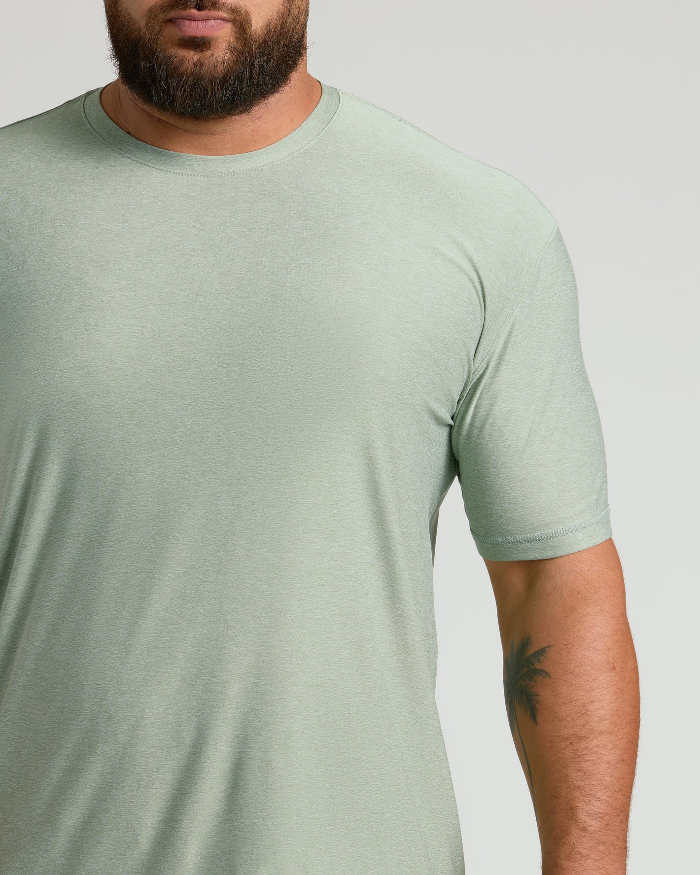 Lichen Active Crew Neck Tee on bearded man, showcasing palm-tree tattoo.