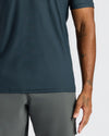 Person wearing a dark green t-shirt and gray pants on a white background
