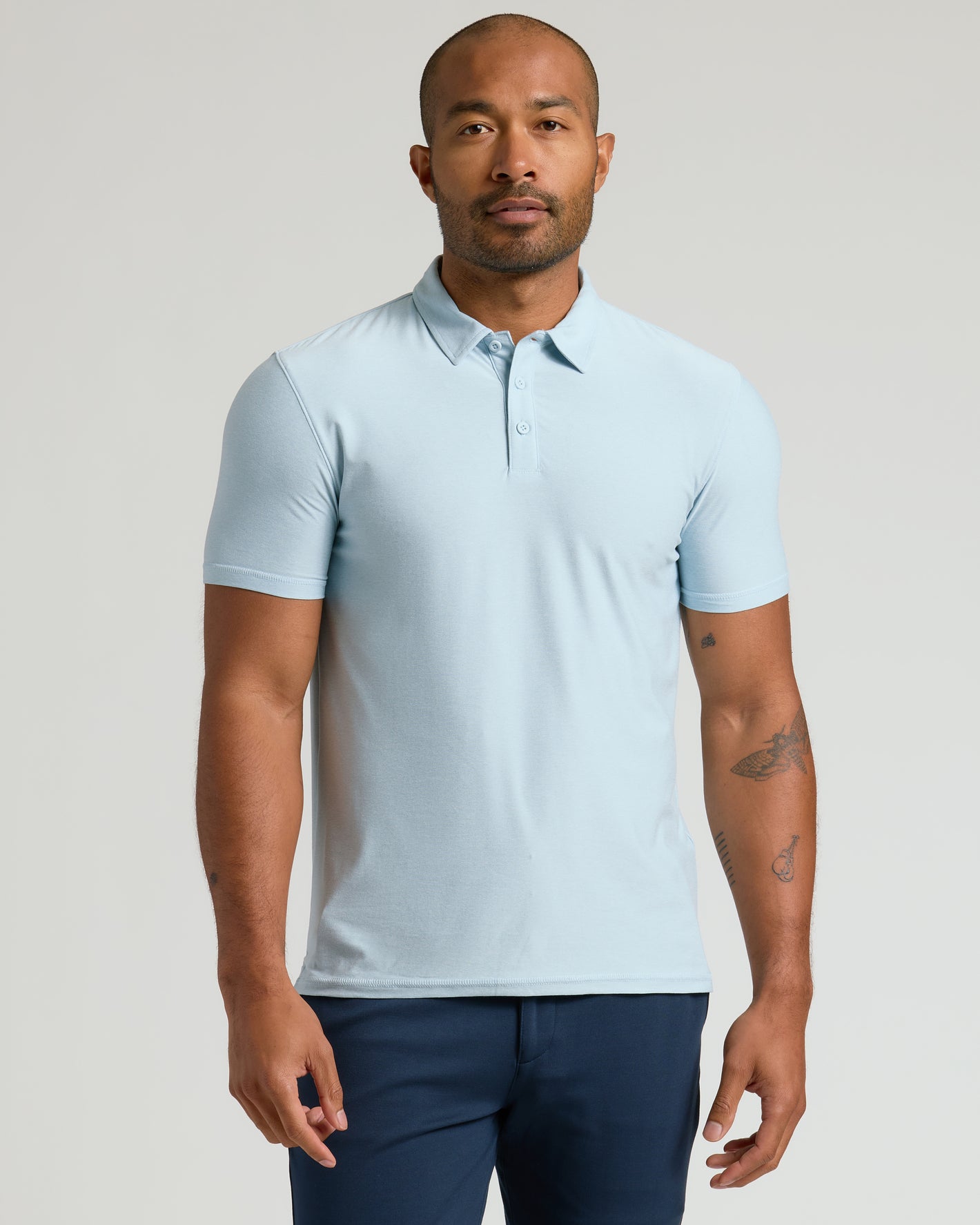 Male model in Arctic Active Polo 2.0 and navy trousers.