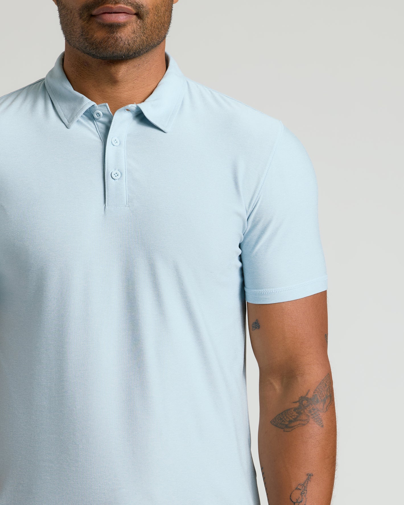 Man wearing the Arctic Active Polo 2.0 with tattoos visible.